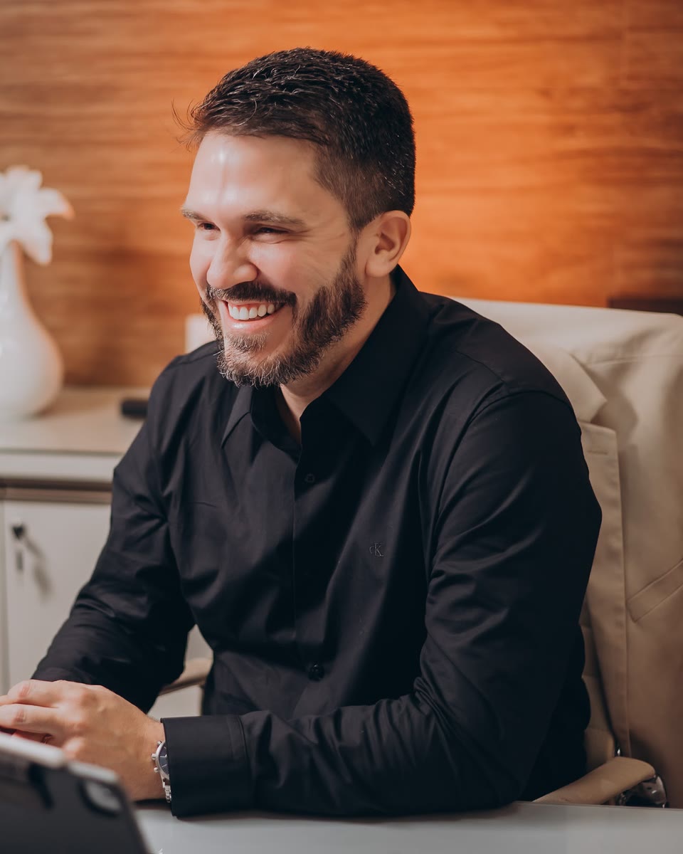 Dr. Victor Cunha sorrindo em seu consultório